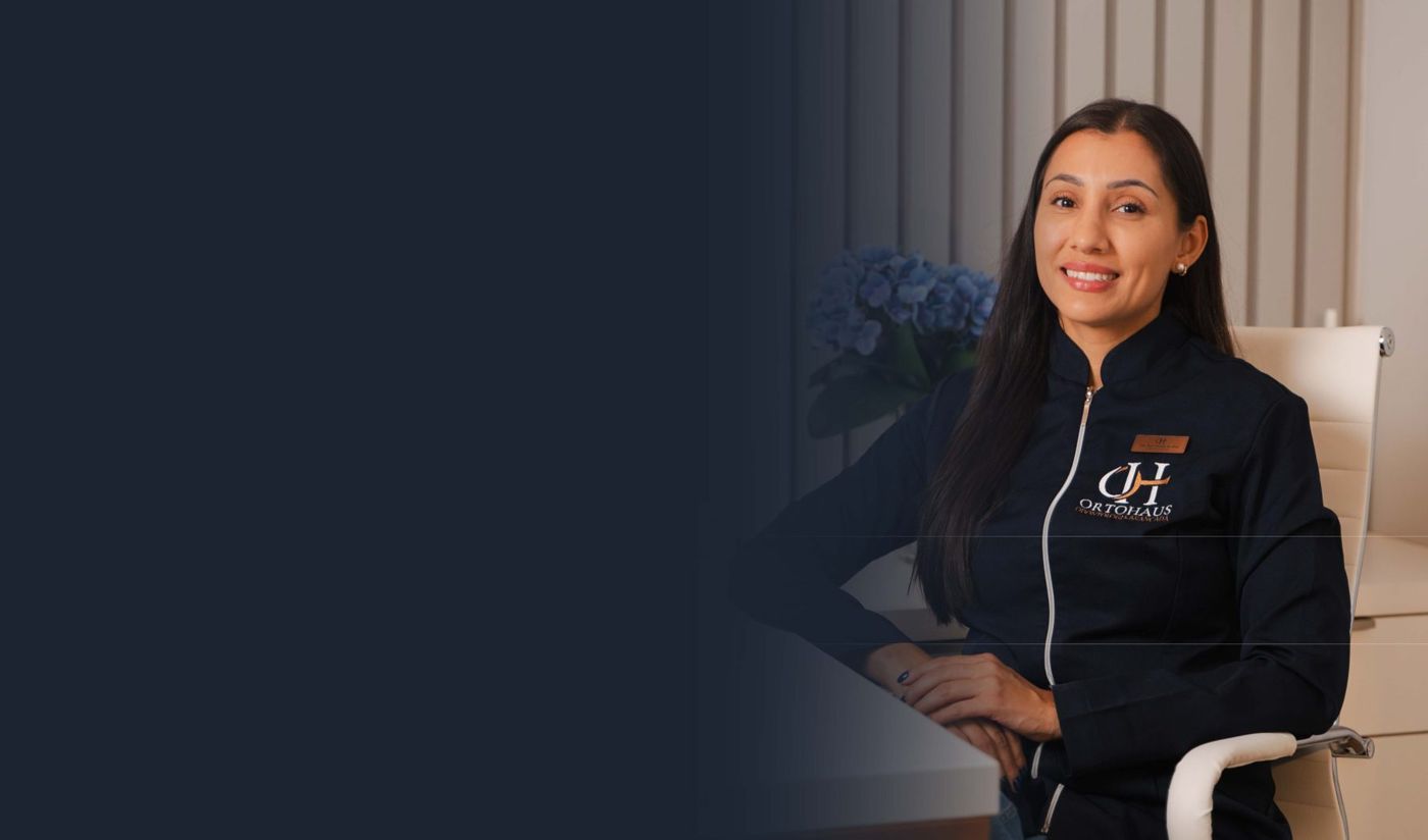 Dra. Ana Cláudia da Silva, cirurgiã-dentista e responsável técnica da OrtoHaus, de uniforme navy, sorrindo